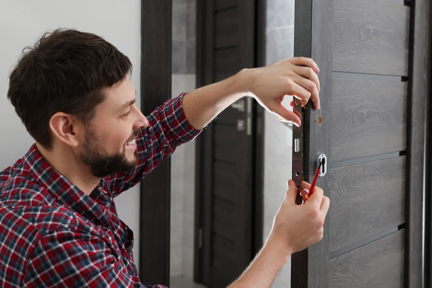 Serrurier de l'atelier familial posant une serrure de porte à Montreuil (93100)