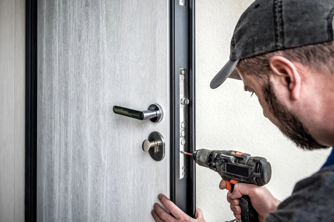Artisan familial renforçant une porte blindée à Montreuil